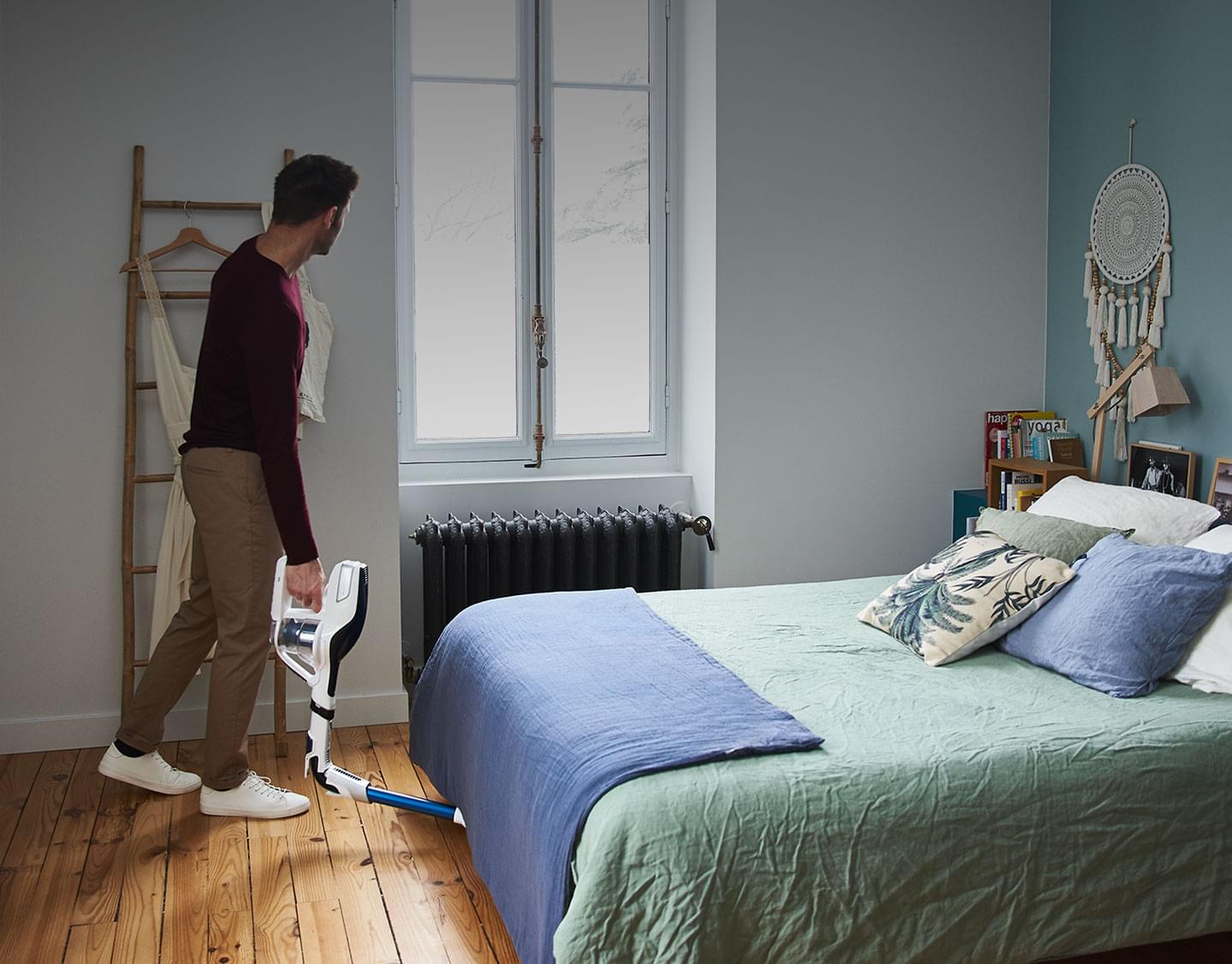 Man vacuuming under a bed